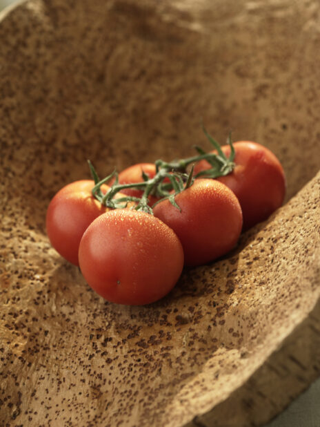 A Bunch of Vine-Ripened Whole Tomatoes on a Wooden Surface