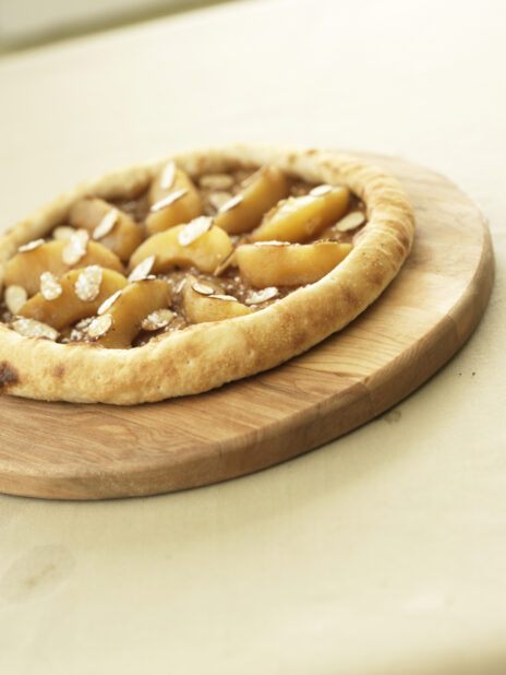 Thick Crust Dessert Pizza with Apple Cinnamon and Sliced Almond Toppings on a Wooden Pizza Peel