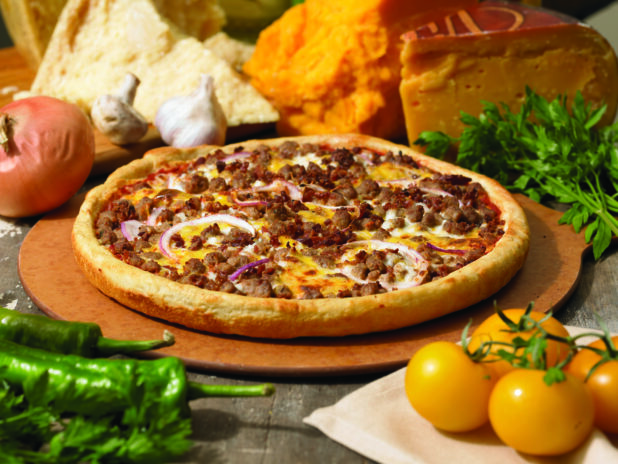 Specialty Cheeseburger Pizza with a Thick Crust on a Wooden Pizza Peel in an Indoor Setting