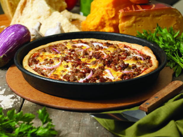 Specialty Thick Crust Cheeseburger Pan Pizza on a Wooden Pizza Peel in an Indoor Setting