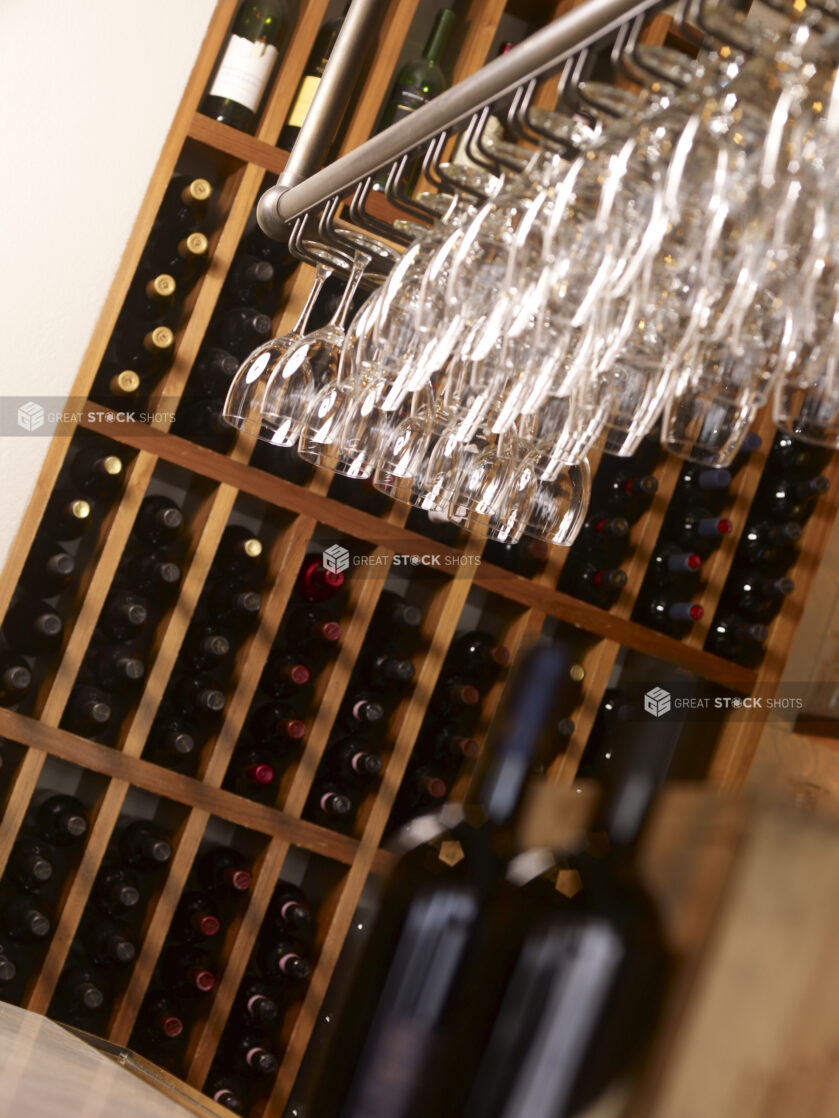 A Restaurant Wine Rack with Bottles of Red Wine and Hanging Wine Glasses