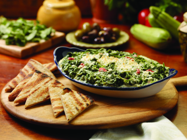 Spanakopita Dip (Greek Spinach and Cheese Dip) with Grilled Pita Bread Wedges on a Wooden Platter on a Wooden Table