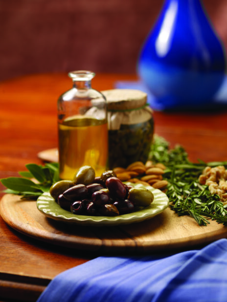 A Side Dish of Kalamata and Green Olives on a Wooden Platter on a Wooden Table