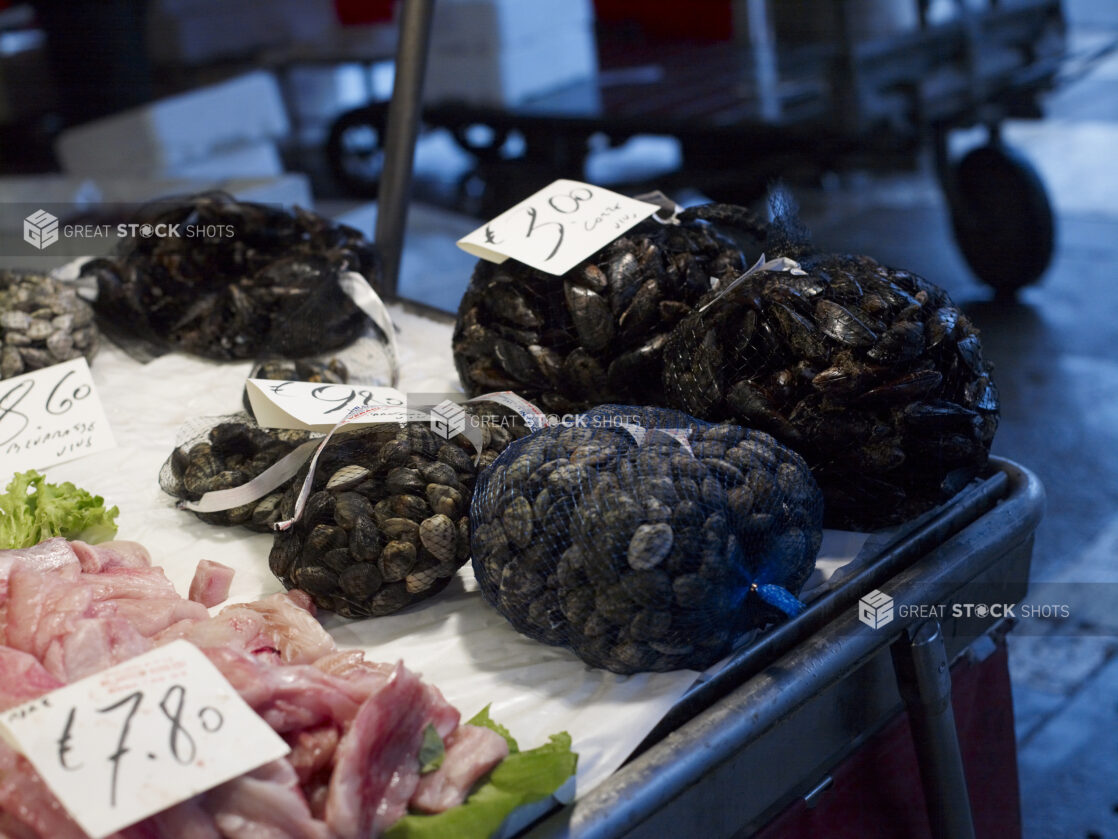 Fresh Clams in Mesh Bags at a Seafood Stall in a Food Market in Venice, Italy