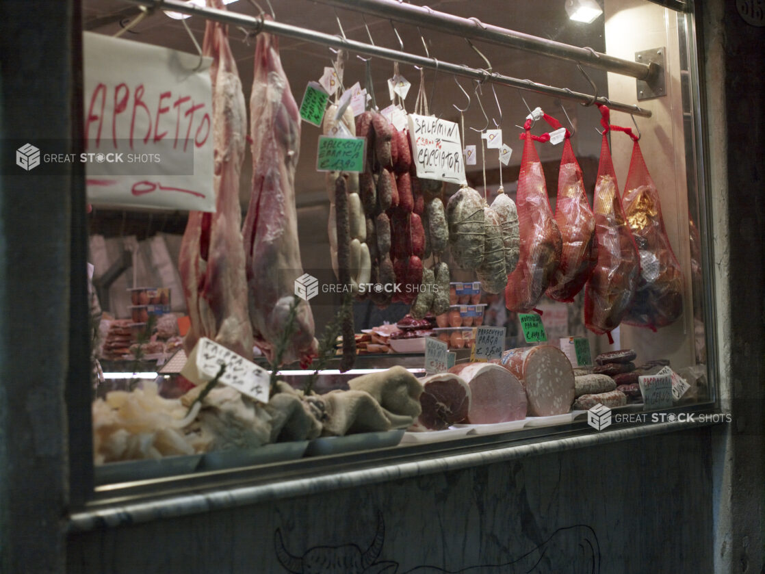 Store Window of a Delicatessen with Hanging Cured Meats in Italy