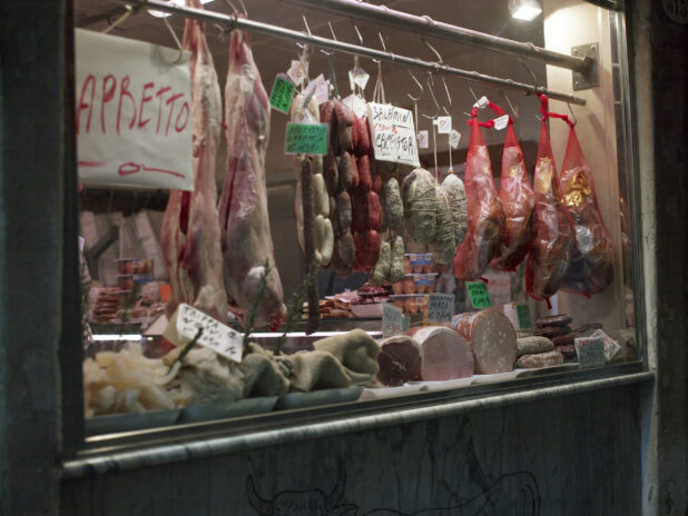 Store Window of a Delicatessen with Hanging Cured Meats in Italy