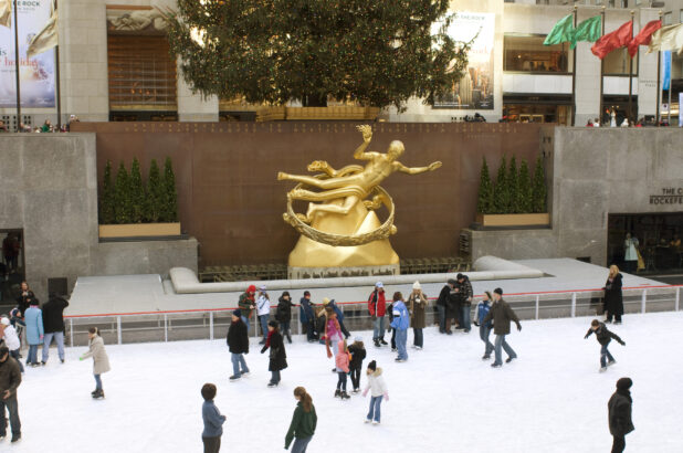 People Skating in Front of the Prometheus Sculpture at an Outdoor Ice Rink in Rockefeller Center during Winter in Manhattan, New York City