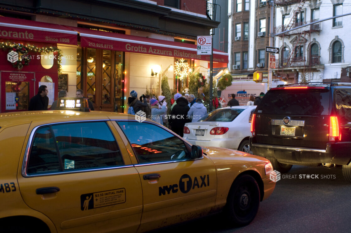 A Yellow NYC Taxi Cab Passing in Front of Grotta Azzurra Ristorante in Little Italy in Manhattan, New York City