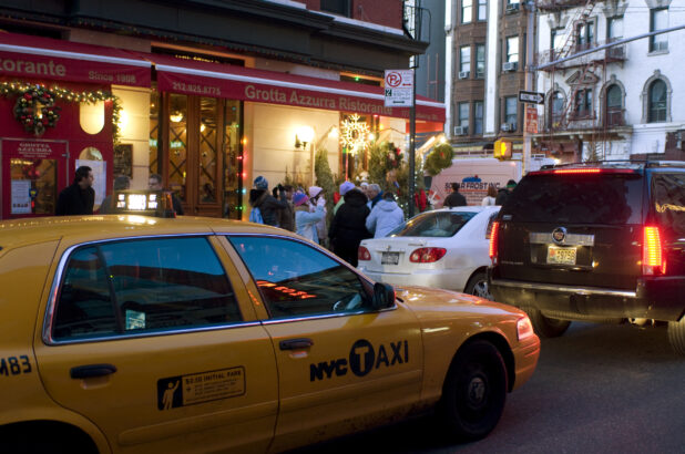 A Yellow NYC Taxi Cab Passing in Front of Grotta Azzurra Ristorante in Little Italy in Manhattan, New York City