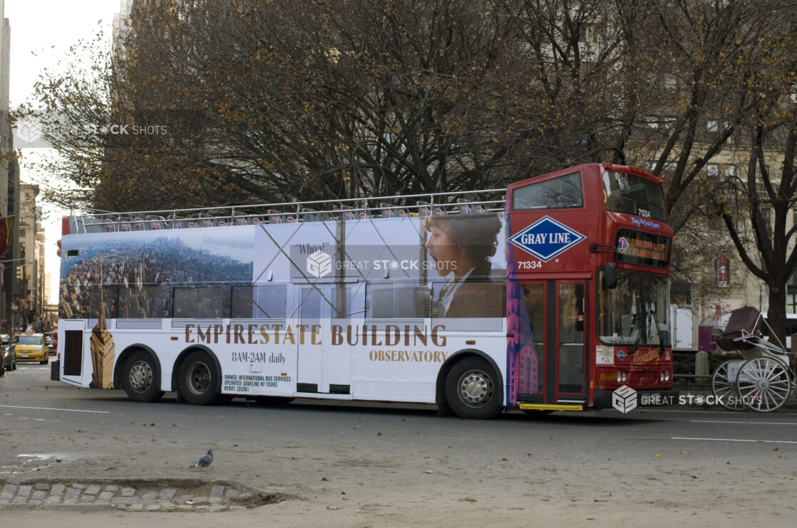 A Double Decker Sightseeing Tour Bus With an Ad Decal For the Empire State Building in Manhattan, New York City