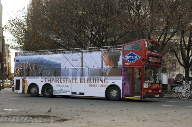 A Double Decker Sightseeing Tour Bus With an Ad Decal For the Empire State Building in Manhattan, New York City