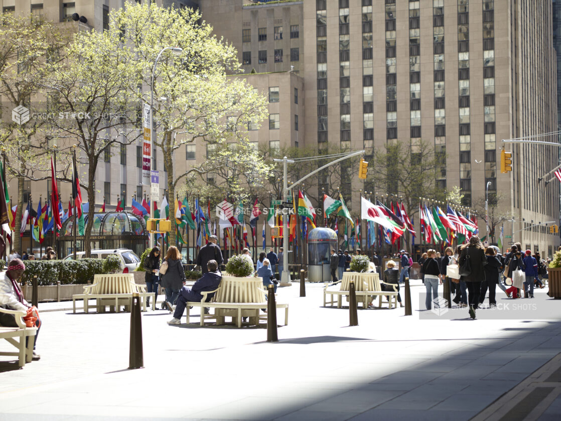 People Sitting on Park Benches Around the Flags of the World at Rockefeller Plaza in Manhattan, New York