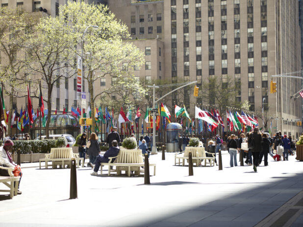 People Sitting on Park Benches Around the Flags of the World at Rockefeller Plaza in Manhattan, New York