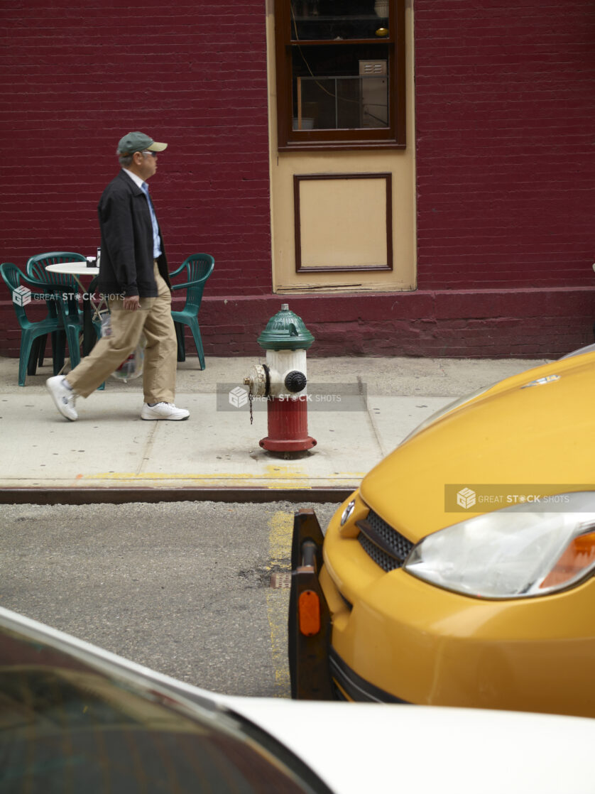 Man Walking Past a Green, White and Red Painted Fire Hydrant in Little Italy, Manhattan, New York City