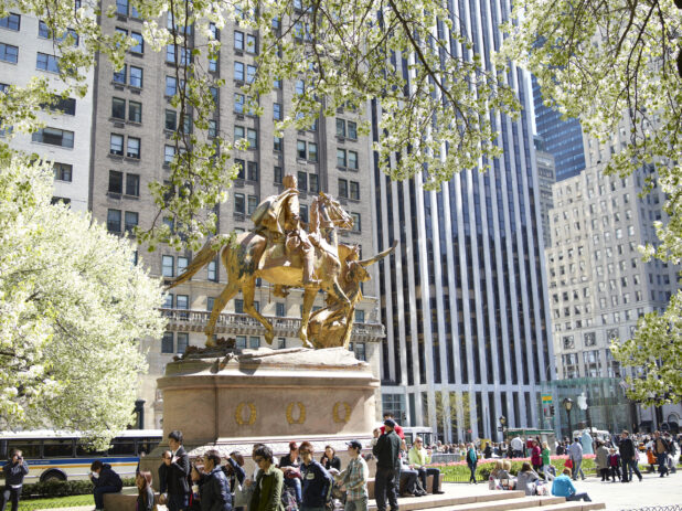 View of Sherman Memorial Statue in Grand Army Plaza Surrounded by People and Concrete Buildings in Central Park, New York City