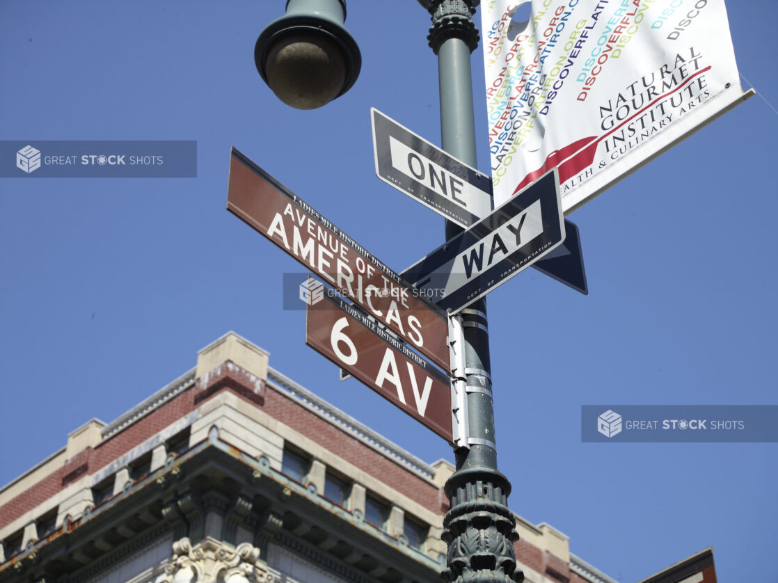 Sixth Avenue, Avenue of the Americas and One Way Street Signs Seen on a Street Lamp Pole in Manhattan, New York City