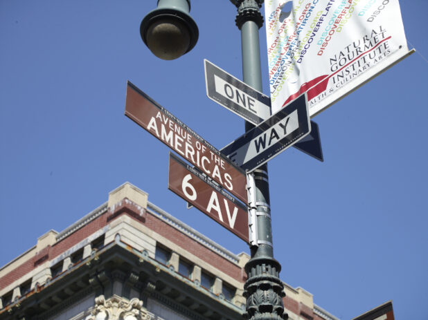 Sixth Avenue, Avenue of the Americas and One Way Street Signs Seen on a Street Lamp Pole in Manhattan, New York City