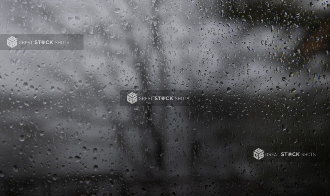 Rain Droplets Against a Window Glass Looking Out into Gloomy Winter Weather