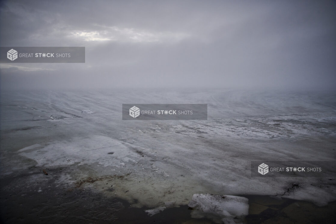 A Frozen, Ice-Covered Lake and Grey Skies Over Cottage Country in Ontario, Canada During Winter