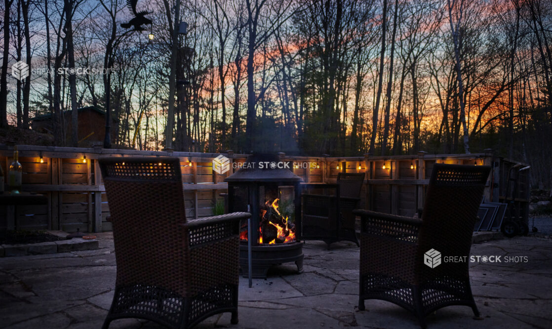 A Pair of Patio Chairs Surrounding a Wood-Burning Stove in a Private Patio Area in Cottage Country in Ontario, Canada
