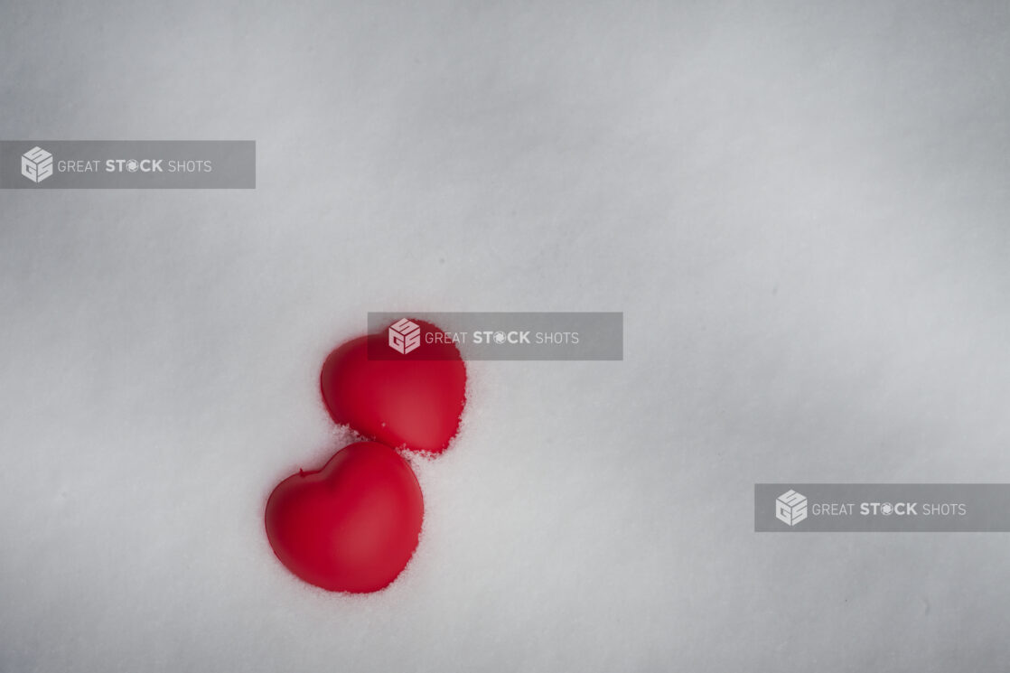 Two Bright Red Hearts Embedded in Fresh, Pristine Snow for Valentine’s Day - Variation