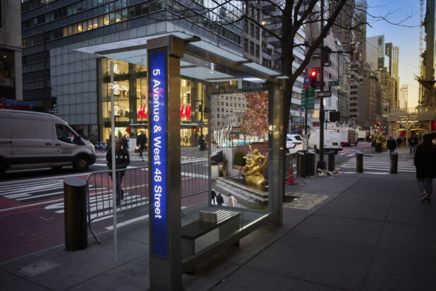 View of a Bus Stop at Fifth Avenue and West 48 Street with a Bus Poster Showing the Rockefeller Center in Manhattan, New York City