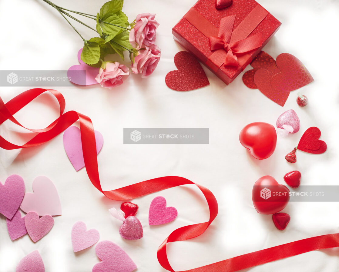 Overhead View of Valentine’s Day Decorations, Roses, Chocolate Hearts and a Gift Box on a White Table Cloth Surface  - 1430032852199