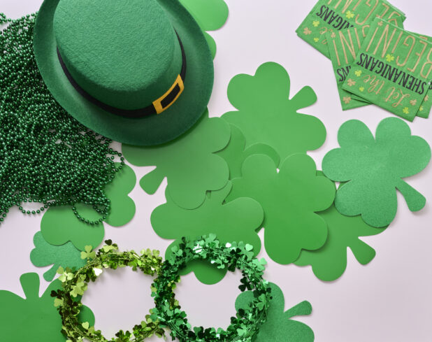 Overhead View of an Assortment of St. Patrick’s Day Decorations – Shamrock Wreaths, Leprechaun Hat, Green Clover Clings and Green Paper Napkins
