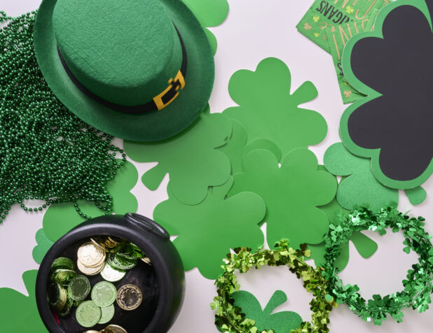 Overhead View of an Assortment of St. Patrick's Day Decorations - Shamrock Wreaths, Leprechaun Hat, Green Clover Clings and a Pot of Gold