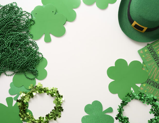 Overhead View of an Assortment of St. Patrick’s Day Decorations – Shamrock Wreaths, Leprechaun Hat, Green Clover Clings and Green Beads