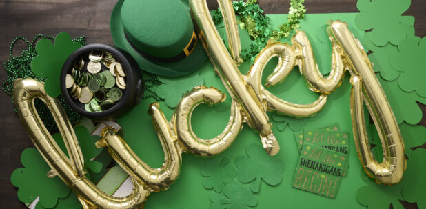 Overhead View of a Gold “Lucky” Balloon Surrounded by St. Patrick’s Day Decorations on a Dark Wood Surface – Variation 2