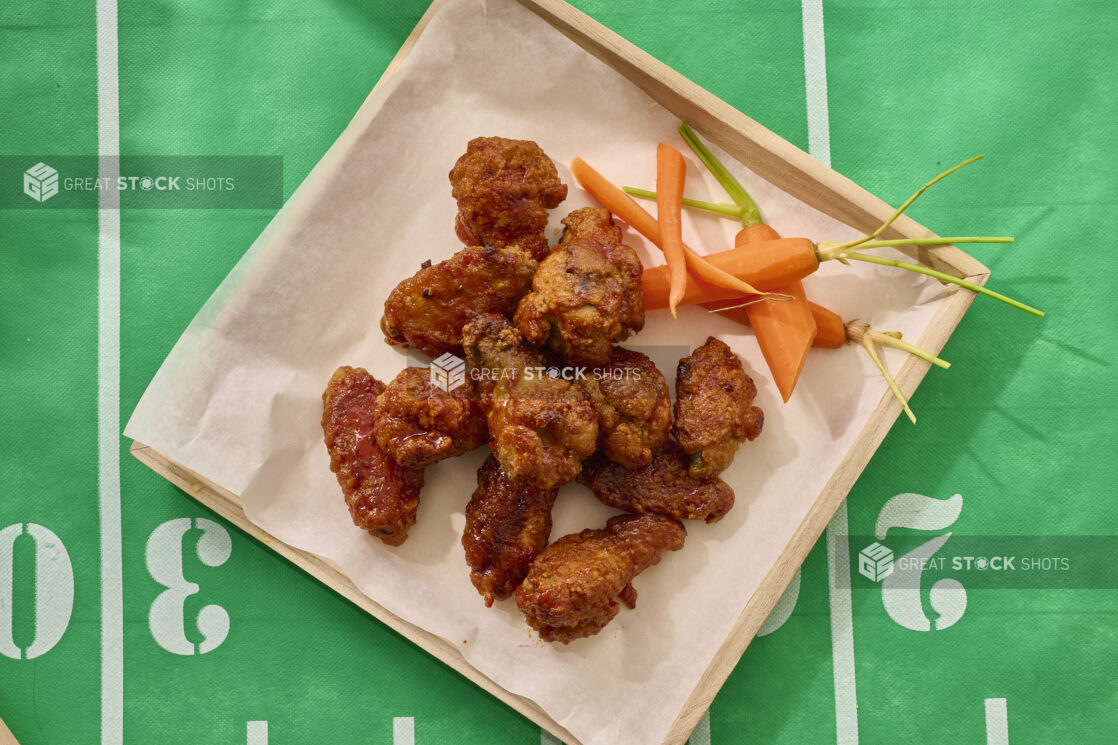 Close Up Overhead View of a Chicken Wings Platter on a Square Wood Tray on a Football Field Table Cloth