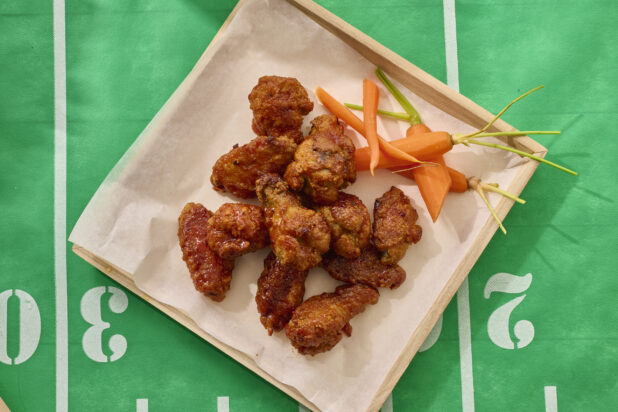 Close Up Overhead View of a Chicken Wings Platter on a Square Wood Tray on a Football Field Table Cloth