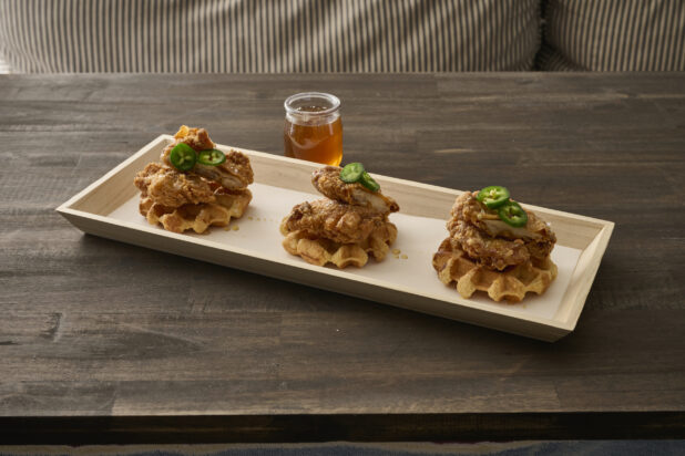 Trio of Fried Chicken and Waffles with Jalapeño Pepper Garnish and Honey Drizzle on a Narrow Rectangular Wood Catering Tray - Variation