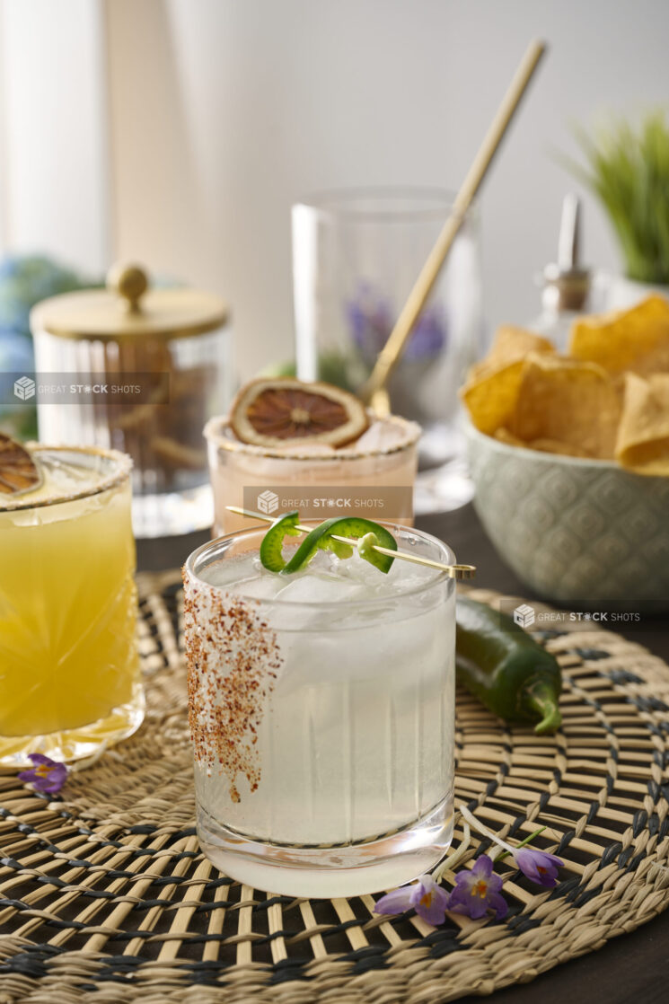 Margarita with Tajin Spice Rim and Jalapeño Pepper Garnish on a Woven Placemat in an Indoor Setting – Sequence 2