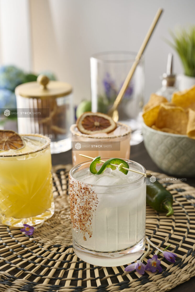 Margarita with Tajin Spice Rim and Jalapeño Pepper Garnish on a Woven Placemat in an Indoor Setting – Sequence 3